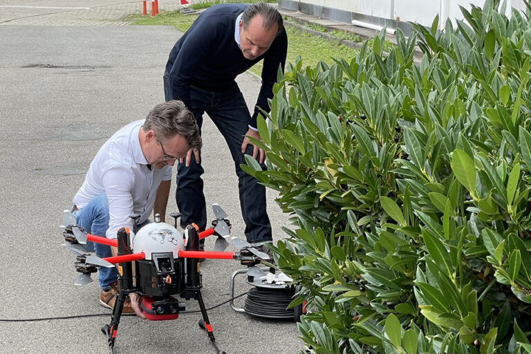 Prof. Dr. Guenter Huhle und Jörg Brinkmeyer (l.) beladen die Drohne mit einem Defibrillator.